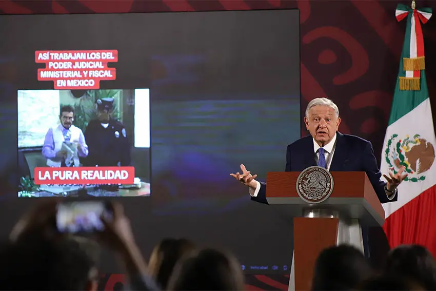 President Lopez Obrador of Mexico speaks at a podium while extending his hand in a gesture.