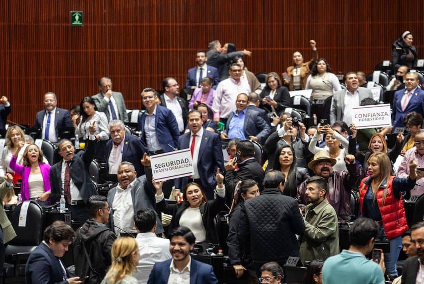 Lawmakers hold up signs during the Congress vote on a bill to put the National Guard under military control