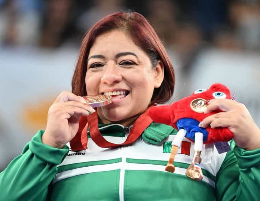 La levantadora de pesas paralímpica Amalia Pérez muerde su medalla de bronce