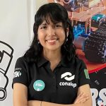 Mexican student Ángela Elena Olazarán poses for a photo with graphics of robots in the background