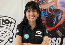 Mexican student Ángela Elena Olazarán poses for a photo with graphics of robots in the background