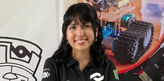 Mexican student Ángela Elena Olazarán poses for a photo with graphics of robots in the background