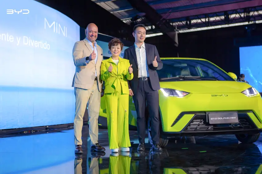 BYD executives stand in front of a BYD Dolphin Mini model