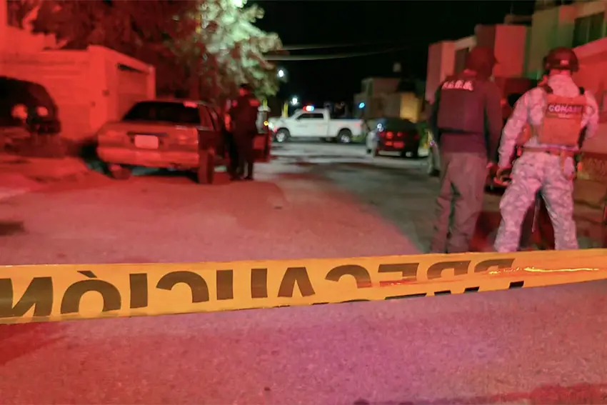 Agentes de la ley mexicanos en una escena del crimen en Guadalupe, Zacatecas, México, con una cinta amarilla de escena del crimen que se extiende a lo largo del primer plano de la fotografía.