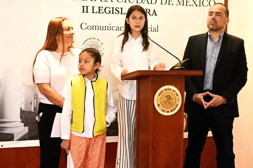 Children stand at a podium with city council members