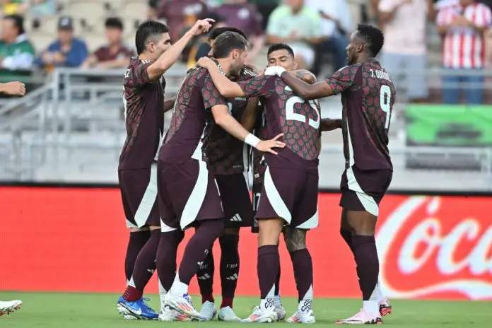 The Mexican men's soccer team hugs and celebrates after beating New Zealand