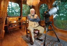 Mexican ufologist Jaime Maussan sits in his living room with a telescope