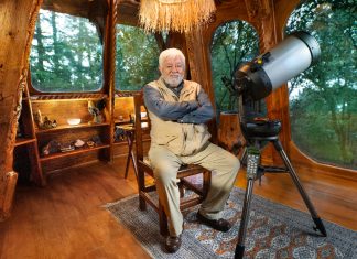 Mexican ufologist Jaime Maussan sits in his living room with a telescope