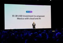 Man alone on a stage in front of an audience and behind a giant projection screen saying $1.3 billion USD investment to empower Mexico with cloud and AI