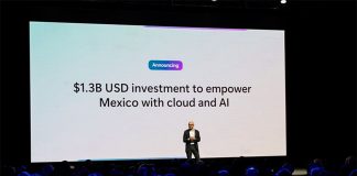 Man alone on a stage in front of an audience and behind a giant projection screen saying $1.3 billion USD investment to empower Mexico with cloud and AI