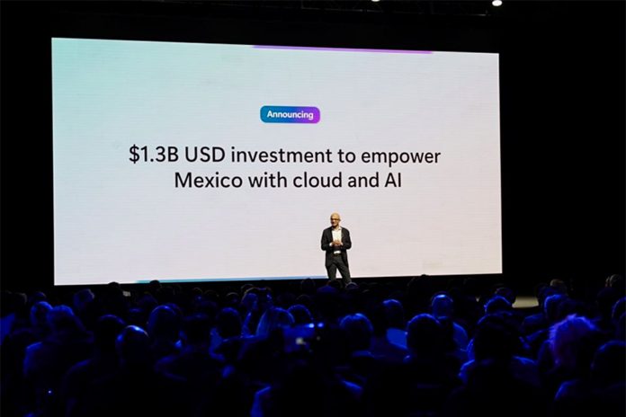 Man alone on a stage in front of an audience and behind a giant projection screen saying $1.3 billion USD investment to empower Mexico with cloud and AI