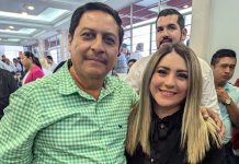 Frontera Comalapa, Chiapas, Mayor-elect Anibal Roblero standing posing for a photo with a young woman with people at an event standing around in the background