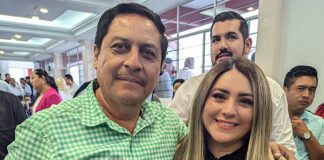 Frontera Comalapa, Chiapas, Mayor-elect Anibal Roblero standing posing for a photo with a young woman with people at an event standing around in the background
