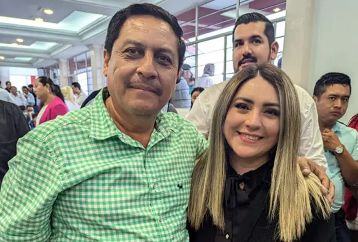 Frontera Comalapa, Chiapas, Mayor-elect Anibal Roblero standing posing for a photo with a young woman with people at an event standing around in the background