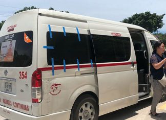 A white 15-passenger van in Tulum with people exiting it.