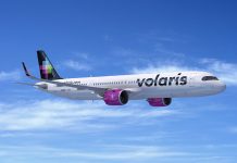 A Volaris Airlines plane in flight with a blue sky background