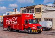 A Coca Cola distribution truck drives down a Mexican street