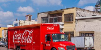 A Coca Cola distribution truck drives down a Mexican street