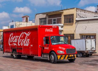 A Coca Cola distribution truck drives down a Mexican street