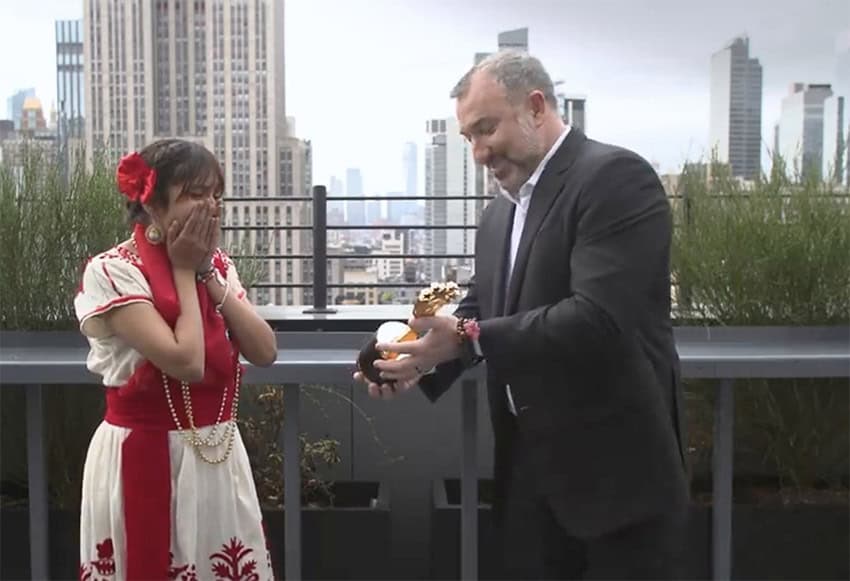 Mexican student Ángela Olazarán receives a trophy for winning the Global Student Prize on top of a New York skyscraper