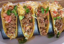 Four hard shell tacos with ground beef and shredded cheese, an example of Tex-Mex cuisine