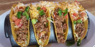 Four hard shell tacos with ground beef and shredded cheese, an example of Tex-Mex cuisine