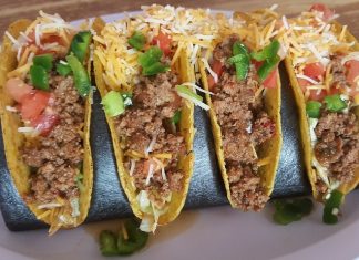 Four hard shell tacos with ground beef and shredded cheese, an example of Tex-Mex cuisine