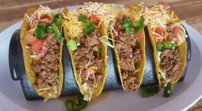 Four hard shell tacos with ground beef and shredded cheese, an example of Tex-Mex cuisine