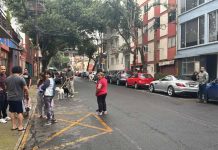 Mexico City residents stand in the street in an earthquake evacuation area, after a series of micro-quakes