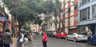 Mexico City residents stand in the street in an earthquake evacuation area, after a series of micro-quakes