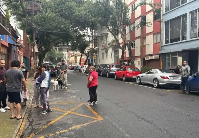 Mexico City residents stand in the street in an earthquake evacuation area, after a series of micro-quakes