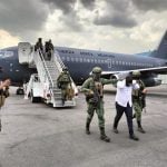 Sedena officials escort a El Piyi off an Air Force plane after his arrest in Sinaloa