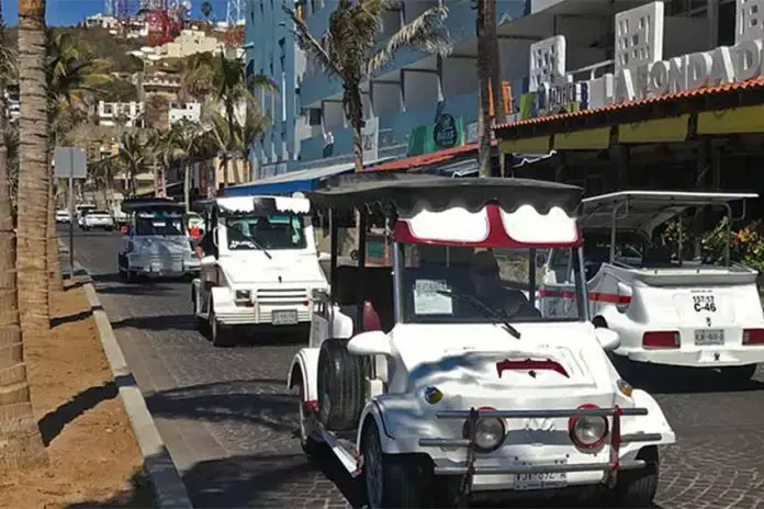 White golf cart taxis driving on the cobblestone streets of downtown Mazatlan, Mexico