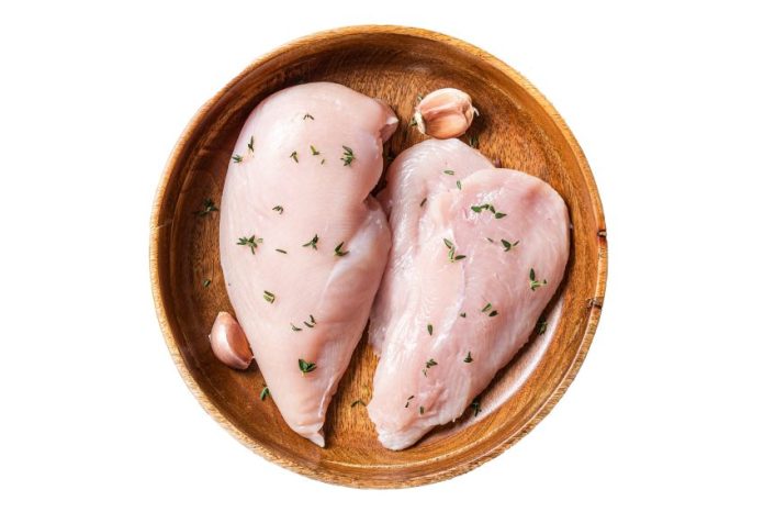 Chicken breast in a wooden dish, of the type used to make mezcal de pechuga