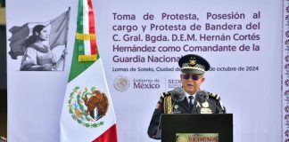 National Guard commander Hernán Cortés Hernández, dressed in military uniform, speaks at a podium next to a Mexican flag