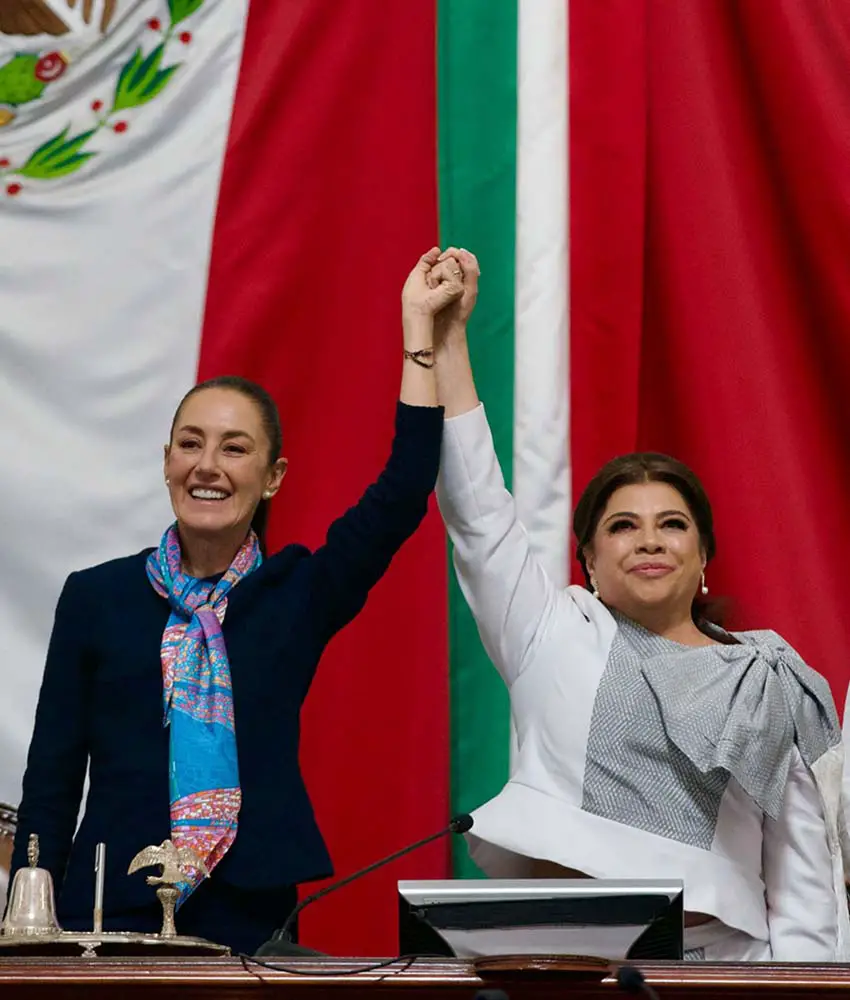 La presidenta de México, Claudia Sheinbaum, y la alcaldesa de la Ciudad de México, Clara Brugada, levantaron la mano en el escenario en la toma de posesión de Brugada.