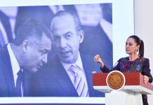 President Claudia Sheinbaum stands at a podium in front of a photo of Felipe Calderón and Genaro García Luna.