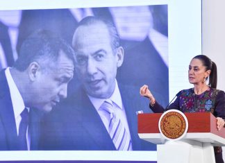 President Claudia Sheinbaum stands at a podium in front of a photo of Felipe Calderón and Genaro García Luna.