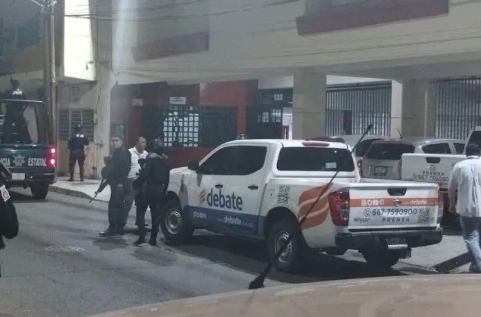 Police stand in front of the El Debate headquarters in Culiacán, Sinaloa