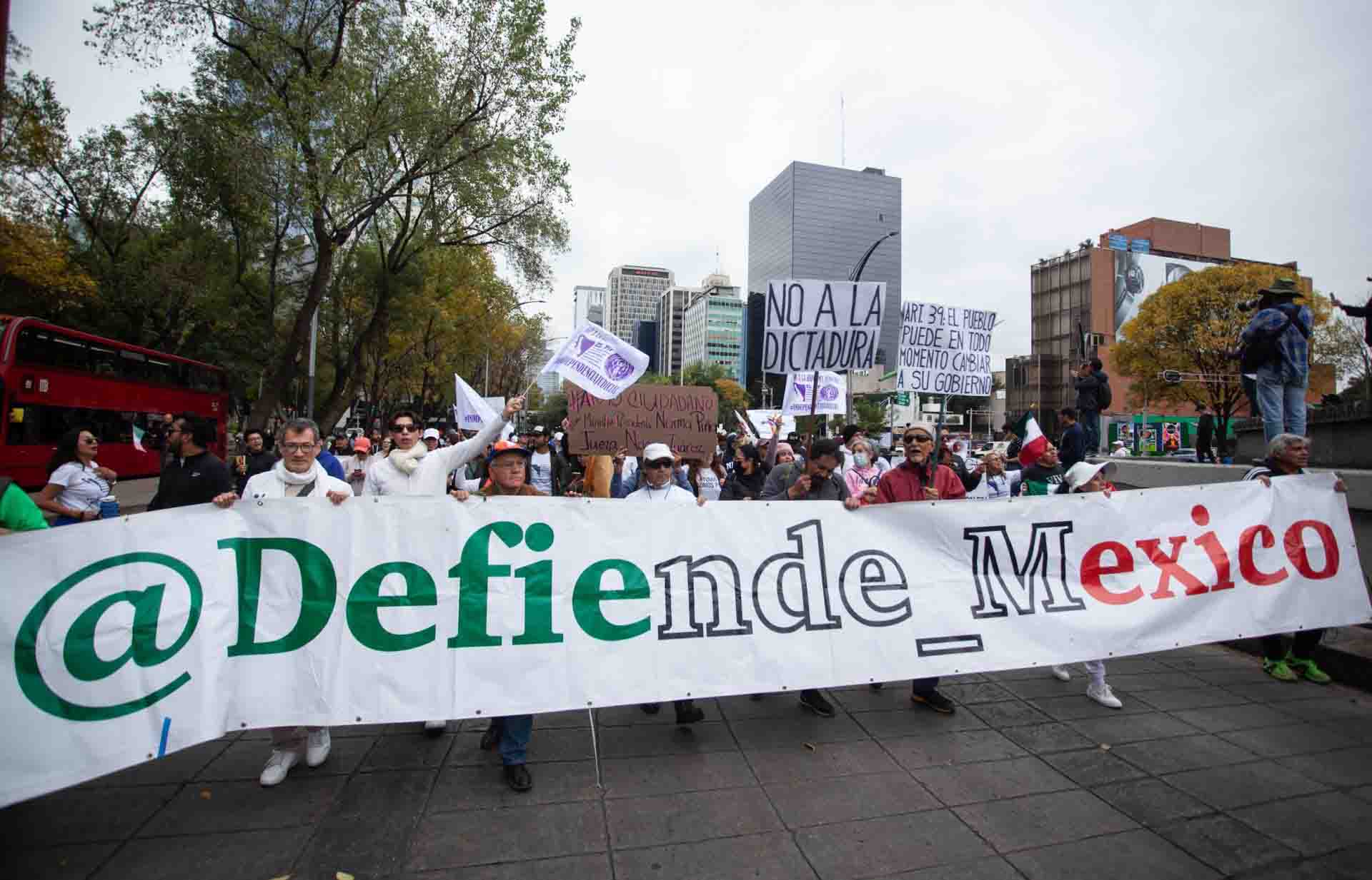 Protesters in Mexico City demonstrating against President Sheinbaum's refusal to comply with Judge Nancy Juarez Salas' order. They hold a banner that says "Defend Mexico"