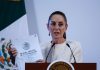 Claudia Sheinbaum at a press conference holding a copy of Mexico's Official Gazette of the Federation document