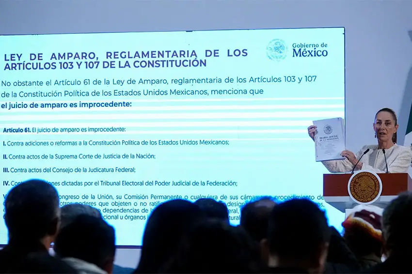 President Claudia Sheinbaum at a press conference. Behind her is a projection of a document with the text of Mexico's Injunction Law