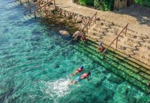 Two people swim in the turquoise waters of the Xcaret Hotel in Quintana Roo