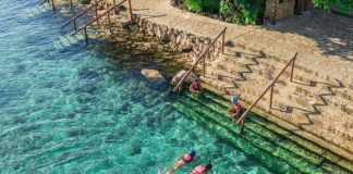 Two people swim in the turquoise waters of the Xcaret Hotel in Quintana Roo