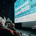 A older man looks up at screen that reads "Festival Internacional de Cine de Morelia" at the 2024 Morelia International Film Festival