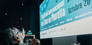 A older man looks up at screen that reads "Festival Internacional de Cine de Morelia" at the 2024 Morelia International Film Festival