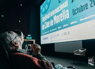 A older man looks up at screen that reads "Festival Internacional de Cine de Morelia" at the 2024 Morelia International Film Festival