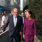 Carlos SLim and Claudia Sheinbaum walking and talking together on a sidewalk in Mexico City