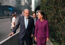 Carlos SLim and Claudia Sheinbaum walking and talking together on a sidewalk in Mexico City