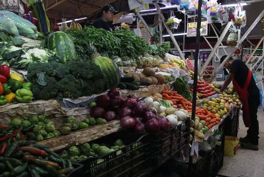 People buying fruits and vegetables in a market in Mexico